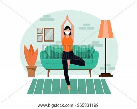 Young Beautiful Slender Girl In A Protective Mask Does Yoga At Home In The Living Room During Quaran