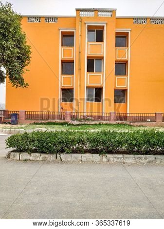Orange Colored House In The City With Multiple Parallel Windows