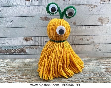 Yellow, Cute Monster With One Eye, Childrens Craft, Made Of Wool Yarn.