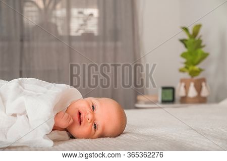Newborn On The Bed. Crying, Screaming Baby Close Up And Copy Space. Baby Smile And Colic In Newborns