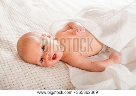 Newborn On The Bed. Crying, Screaming Baby Close Up And Copy Space. Baby Smile And Colic In Newborns