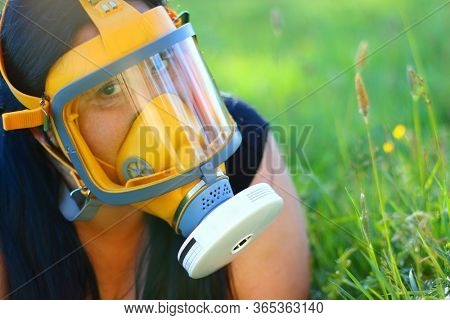 Woman in protection mask on a meadows. Allergy and infection control concept. Hayfever or covid-19 hazard.