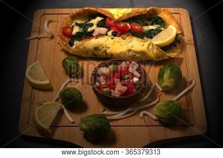 An Omelet With Tomatoes, Spinach, Cheese And Argentinian Salsa Criolla