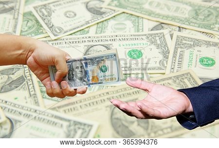 Hand Hold Many Dollar Banknotes And Another One Act Receive That Money With Dollar Background. Corru