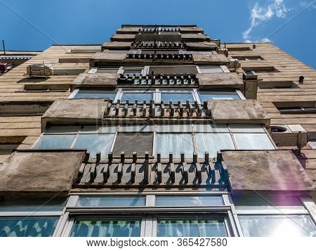 Worn Out Apartment Building From The Communist Era Against Blue Sky In Bucharest Romania.