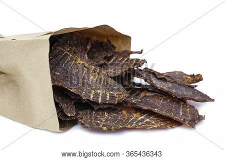 Dry Jerky Jerky For Beer. Beef Jerky Pieces In A Paper Bag On White Background, Isolated