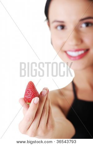 Giovane donna felice con fragola. Focalizzata su strowberry.