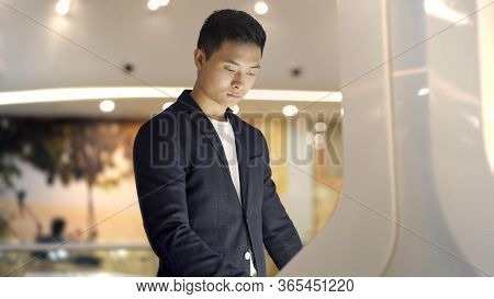Young Businessman Hands Dressed In Jacket Swiping For Information In Kiosk On Background Of Lights O