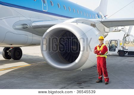 Jetmotor mekaniker udgør ved siden af et kommercielt fly på startbanen