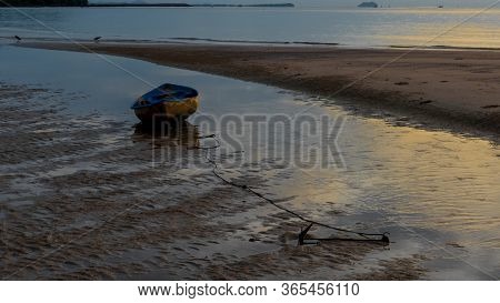 Dinghy Sitting In Tidal Pool At Beach At Low Tide During Sunset In Pythiu On The Gulf Of Thailand Wi