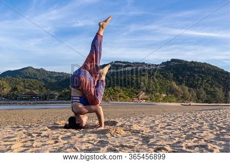 Asian Thai Woman Practicing Yoga At Evening In Mae Haad Beach, Koh Phangan Island, Thailand. Headsta