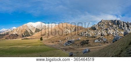 Mountain Valley With Huge Boulders And Snow Capped Mountains. Castle Hill, New Zealand