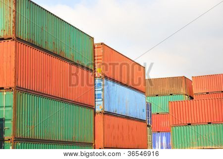 Stakken af fragtcontainere ved solopgang i en intermodal værftet
