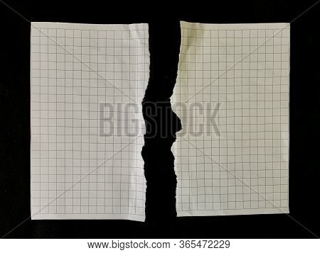 Two Halves Of Torn Paper, On A Black Background. The Sheet Of The Notebook Was Torn In Half. Empty P