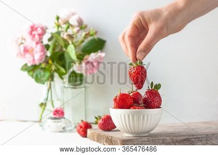 Woman Takes Or Puts One Strowberry In Fruit Bowl Full Of Fresh, Red, Jucy Strawberries. Pastel-color