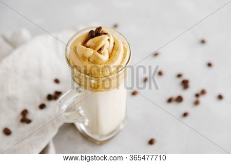 A Glass With A Cool Trendy Dalgon Coffee Drink In Vegetable Or Plain Milk. Linen Napkin, Coffee Grai