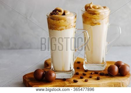 Two Glasses Of Dalgon Stand On A Wooden Board And Next To Them Are Chocolates. Trendy Milk Drink Wit