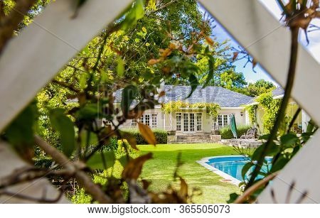 Wide Angle View Of Exterior Of Upmarket Wealthy Suburban Mansion House With Landscaped Garden And Sw