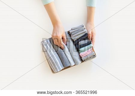 Box With Brught Socks, Closeup Hands. Sort Up Socks. White Background. Basket.