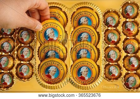 Tambov, Russian Federation - April 30, 2020 Woman Hand Taking Candy From Box Filled Of Mozartkugeln 