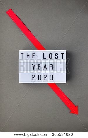 Crisis Composition With Lightbox With The Lost Year 2020 Slogan And Red Down Arrow On Grey Paper Bac