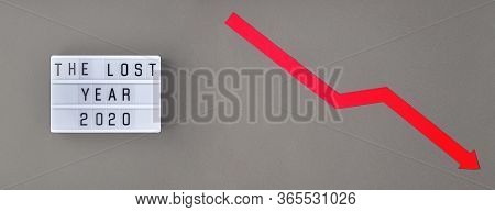 Crisis Composition With Lightbox With The Lost Year 2020 Slogan And Red Down Arrow On Grey Paper Bac