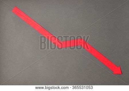 Crisis Composition With Red Down Arrow On Grey Paper Background. Flat Lay Top View, Minimal Style Wi