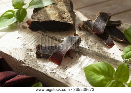 Dried Roe Deer Meat On A Rustic Shabby Cutting Board
