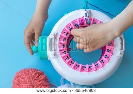 Girl Knits On A Knitting Machine. Children's Crafts Made Of Yarn.