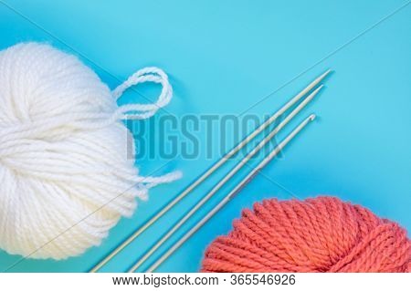 Clew White And Red Yarn With Knitting Needles On A Blue Background