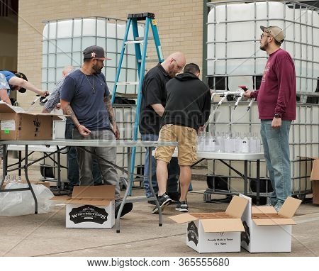 Houston, Tx - March 31, 2020: Staff At Whitmeyer's Distilling Co. Filling Glass Bottles With Hand Sa