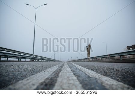 The Dividing Line On The Road Is White The View From Below On The Road Paved Going. Road Markings On