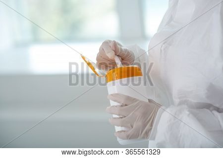 Close-up Of Medical Worker Hands Holding Disinfecting Wipes Bottle, Pulling Out One