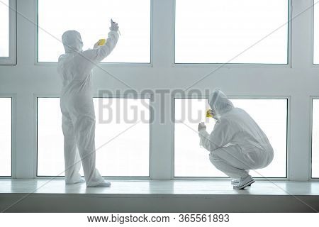 Medical Workers In Protective Clothing And Medical Masks Cleaning And Disinfecting Window Panes