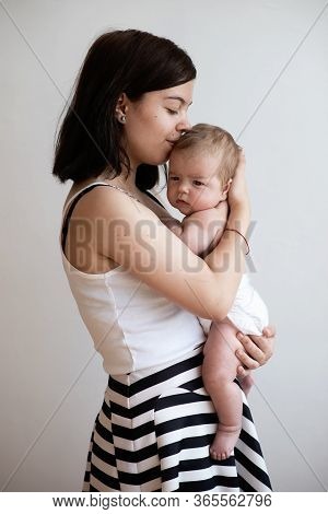 A Teenage Girl Holds Her Little Younger Sister In Her Arms, Tender Hugs, Kindred Feelings.