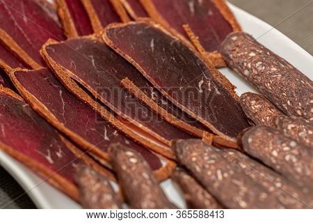 Basturma Beef Jerky. Dried Meat Beef Or Meat Smoked Jerky With Spices On A White Plate. Armenian Foo