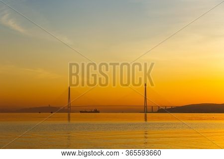 Dawn In The Sea City Of Vladivostok. Cable-stayed Russian Bridge Over Vostochny Bosphorus Strait To 
