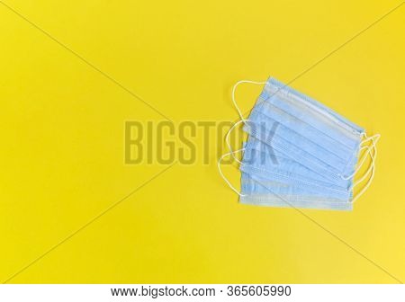 Three Medical Maska On The Yellow Background. Pandemic Concept. Copy Space. Place For Text And Desig