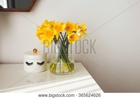 Modern Minimalist White Room Interior With Yellow Flowers Satnding On The Table In Natural Sunlight 