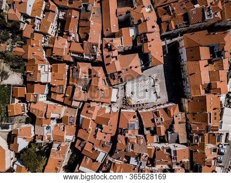 Aerial Top Down Drone View On Piran Town With Narrow Streets, Ancient Buildings With Red Roofs And P