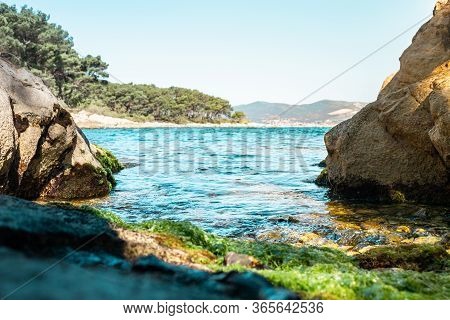 Tiny Hidden Beach Surrounded By Rocks On The Shore Of Split, Croatia. Green Sea Grass On The Rocks. 