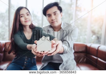 Couple Hands Holding Housing Model For Future Real Estate Saving, Attractive Asian Couple Hand Joint