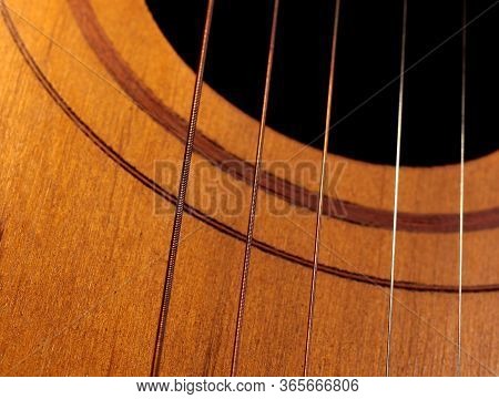 Sound Hole Of The Guitar With The Strings For The Background.