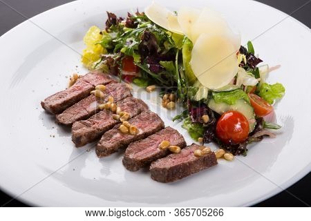 Grilled Roast Beef Salad Served With Arugula And Parmesan Cheese