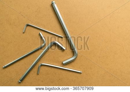 Set Of Hex Wrenches On Plywood Background. Copy Space.