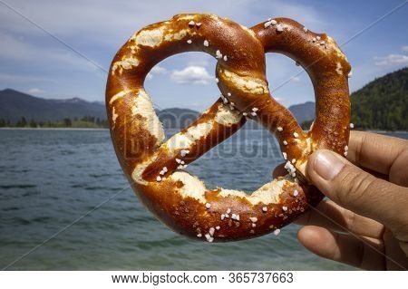 Hand Holding A Pretzel At Walchensee In Spring