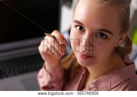 Girl In Office Sits In Front Laptop And Holds Pen. Inexperience, Excitement And Insecurity In Workpl