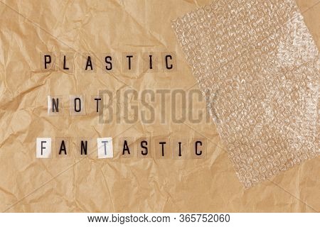 Bubble Wrap, Phrase From Letters On Transparent Base Plastic Not Fantastic On Brown Crumpled Craft P