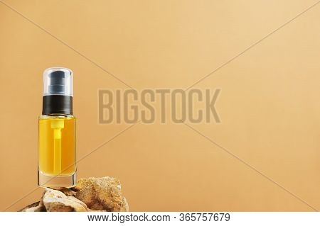 Unbranded Bottle With Dispenser On Stones. Transparent Container With Oil For Facial Lotion On Natur
