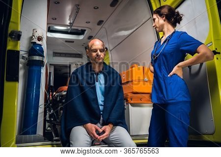 A Female Paramedic Providing First Aid To An Injured Man Resqued From The Fire